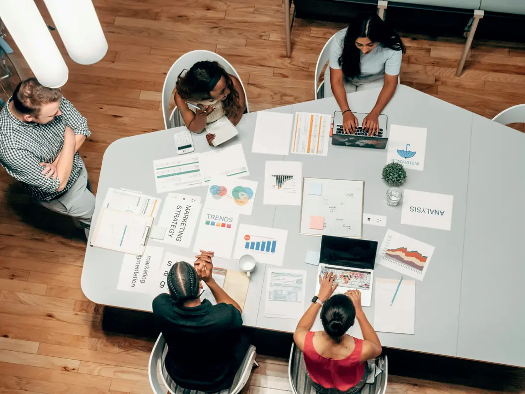Équipe en atelier de stratégie autour d’une table couverte de documents